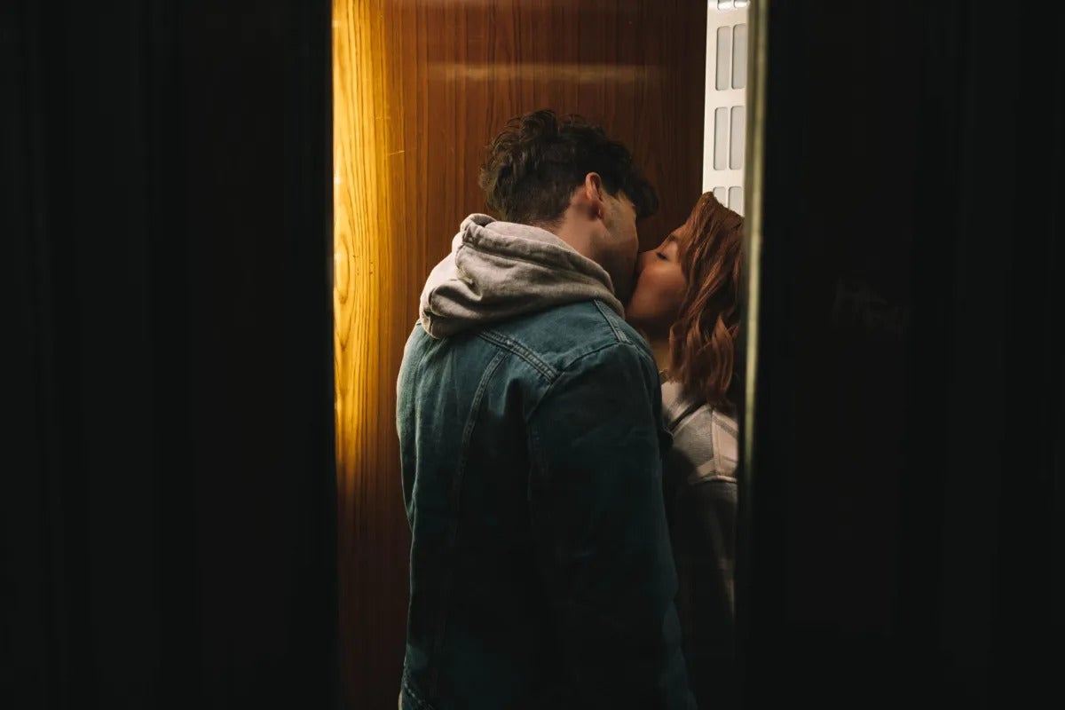 1 homme et une femme qui s'embrassent dans l'ascenseur