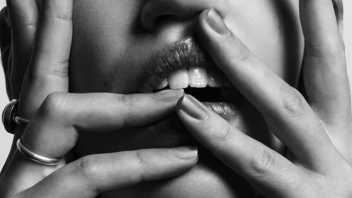 gros plan d'une bouche de femme avec ses mains sur ses joues