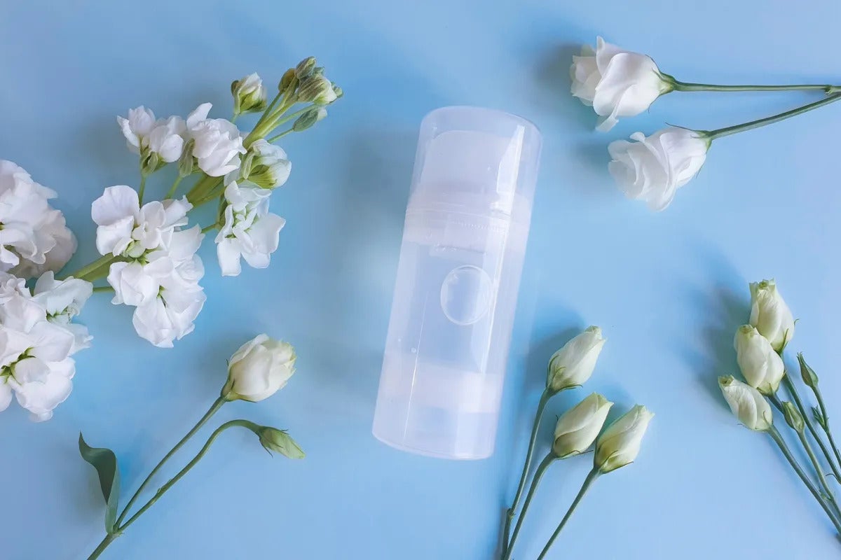 Un lubrifiant entouré de fleurs sur fond bleu