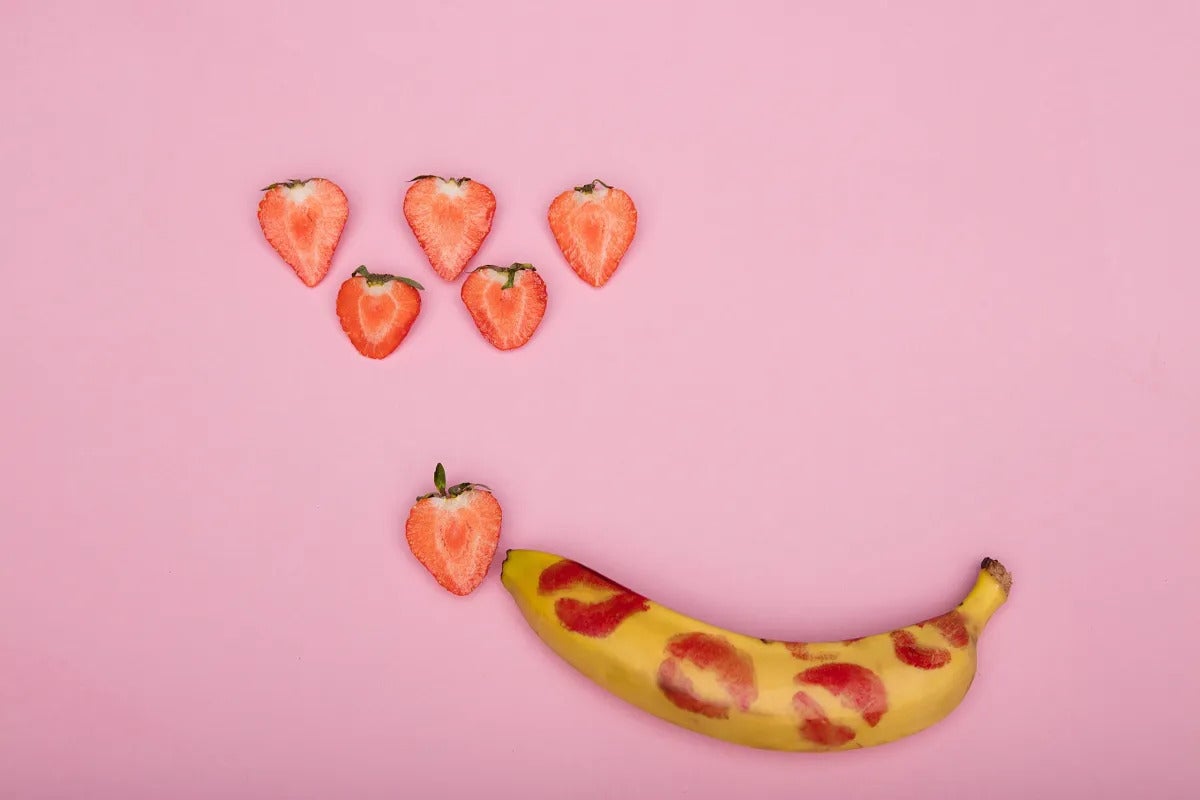 une banane avec des marques de rouge à lèvres et des fraises