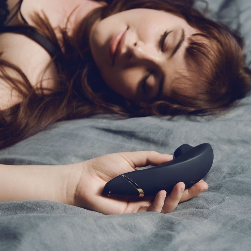une femme allongée en tenant son womanizer