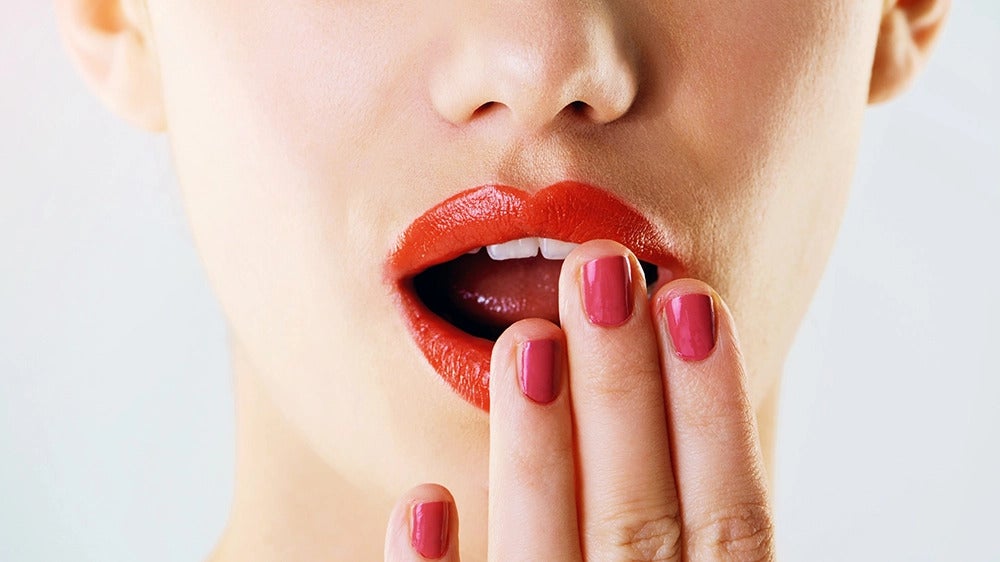 une femme qui met sa main devant la bouche