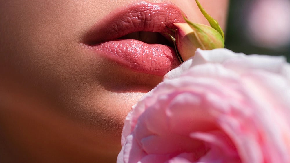 une femme avec une rose sur la bouche