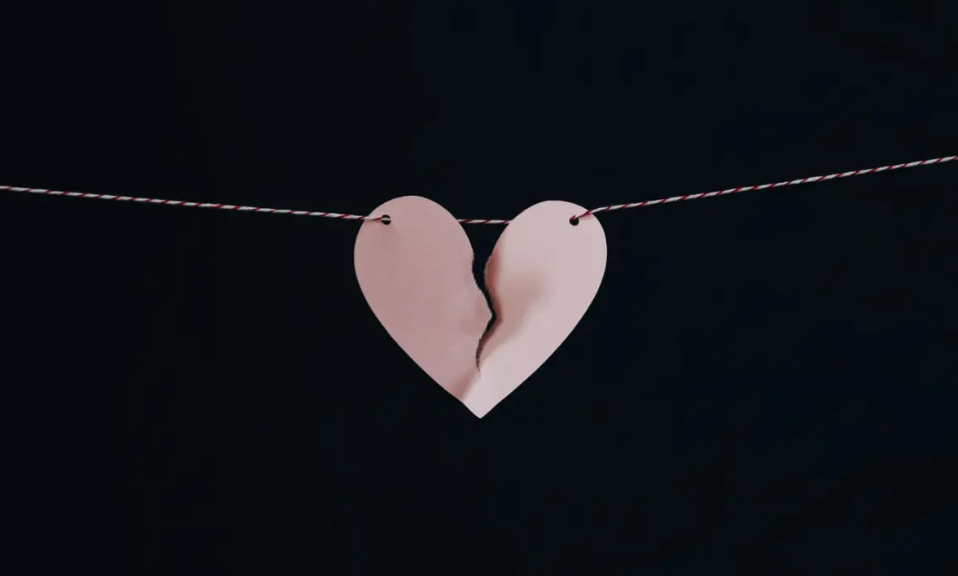 C&oelig;ur en papier d&eacute;chir&eacute; suspendu sur un fil symbolisant un couple qui souhaite raviver la flamme