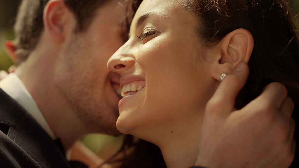 Couple échangeant un moment de complicité en extérieur.